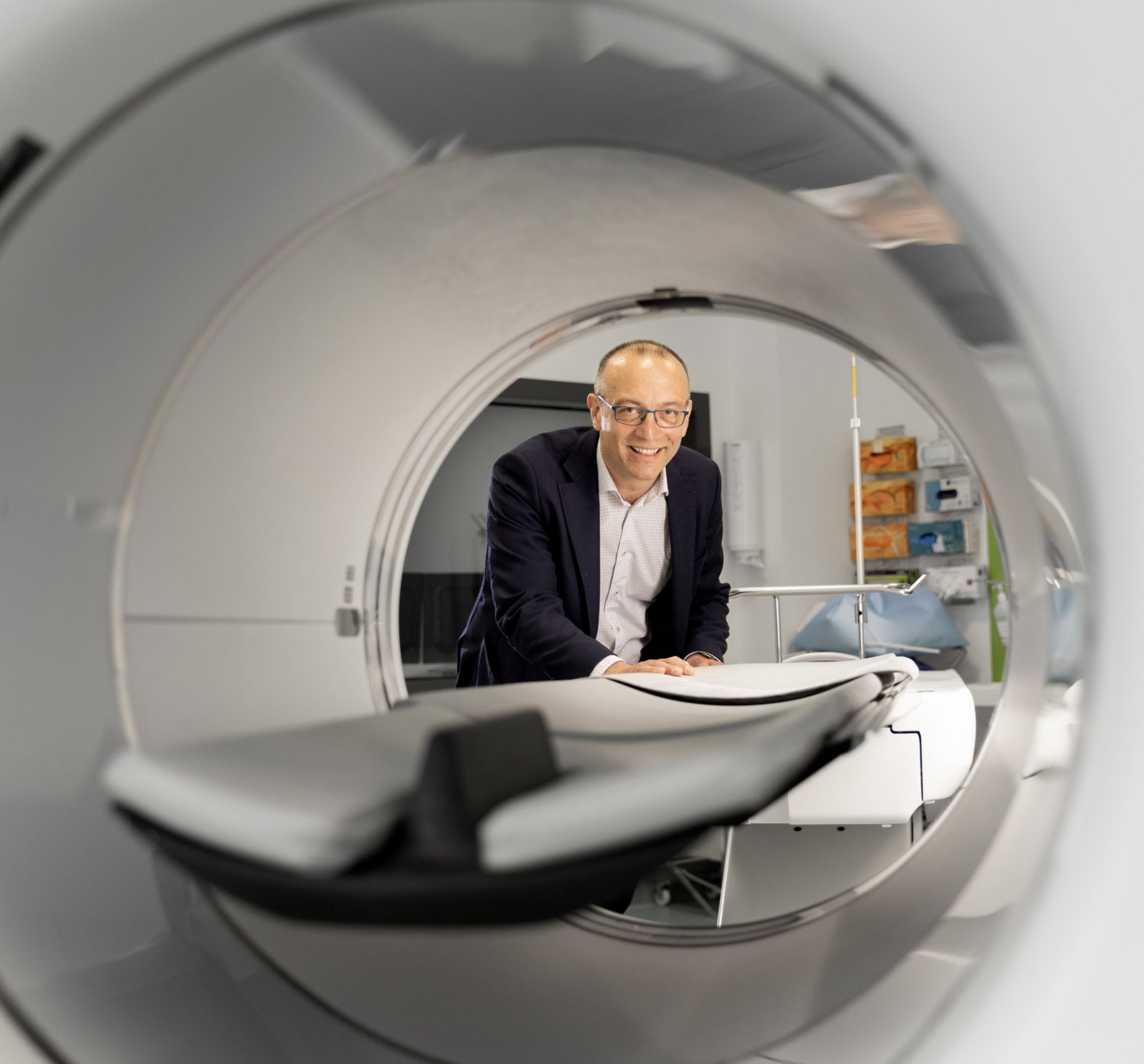 Portrait of Andrea Varrone and a PET camera.