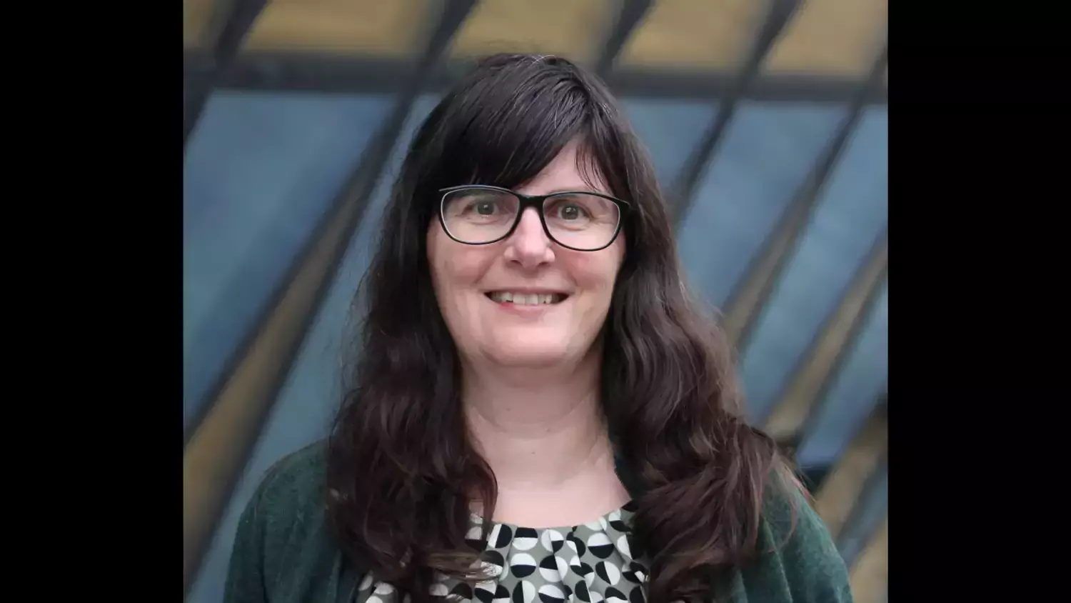 Profile photo of Anna Zorzet, a woman with long brown hair, a black jacket and patterned top