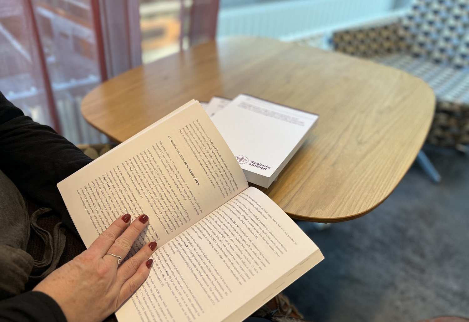 Kvinna läser i en bok, en avhandling.