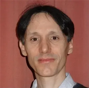 Huvudporträtt av Matteo Bottai som står mot en tegelröd bakgrund.