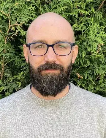 Close-up with Pablo Lopez standing in front of a green bush