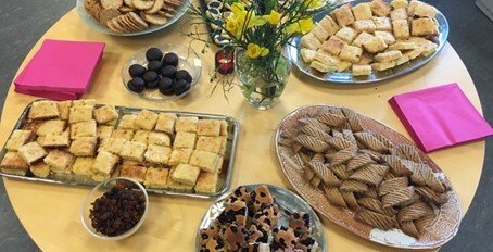 Table with plates of cakes and fruit