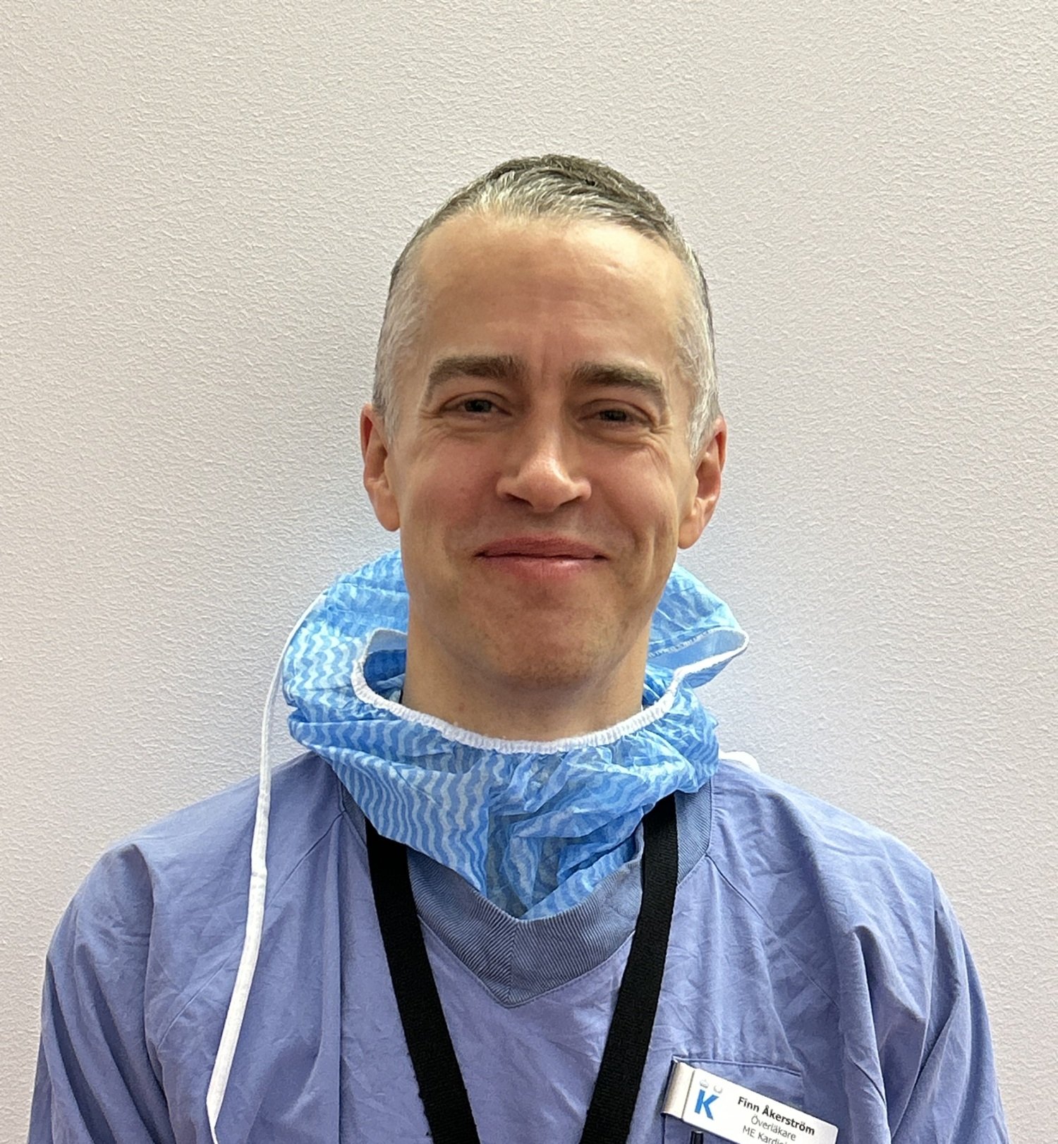 Porträtt på leende man i läkarkläder.