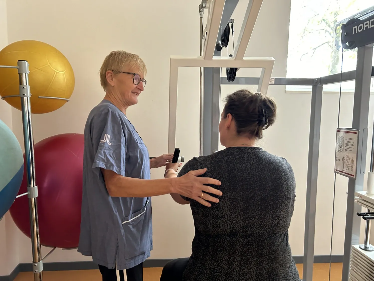 En fysioterapeut som instruerar en patient som tränar.