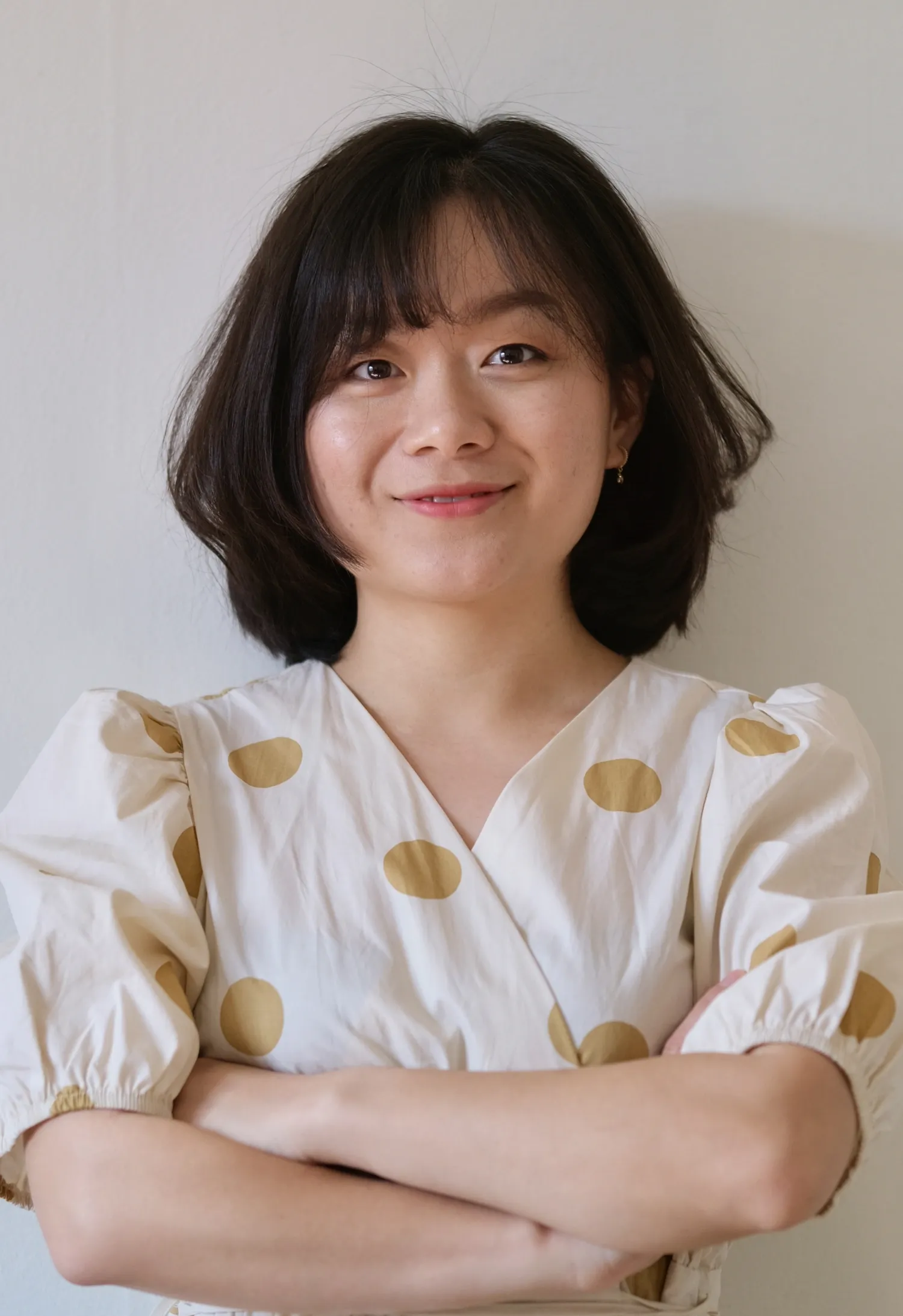 Portrait of Jing Wu standing with her arms crossed.