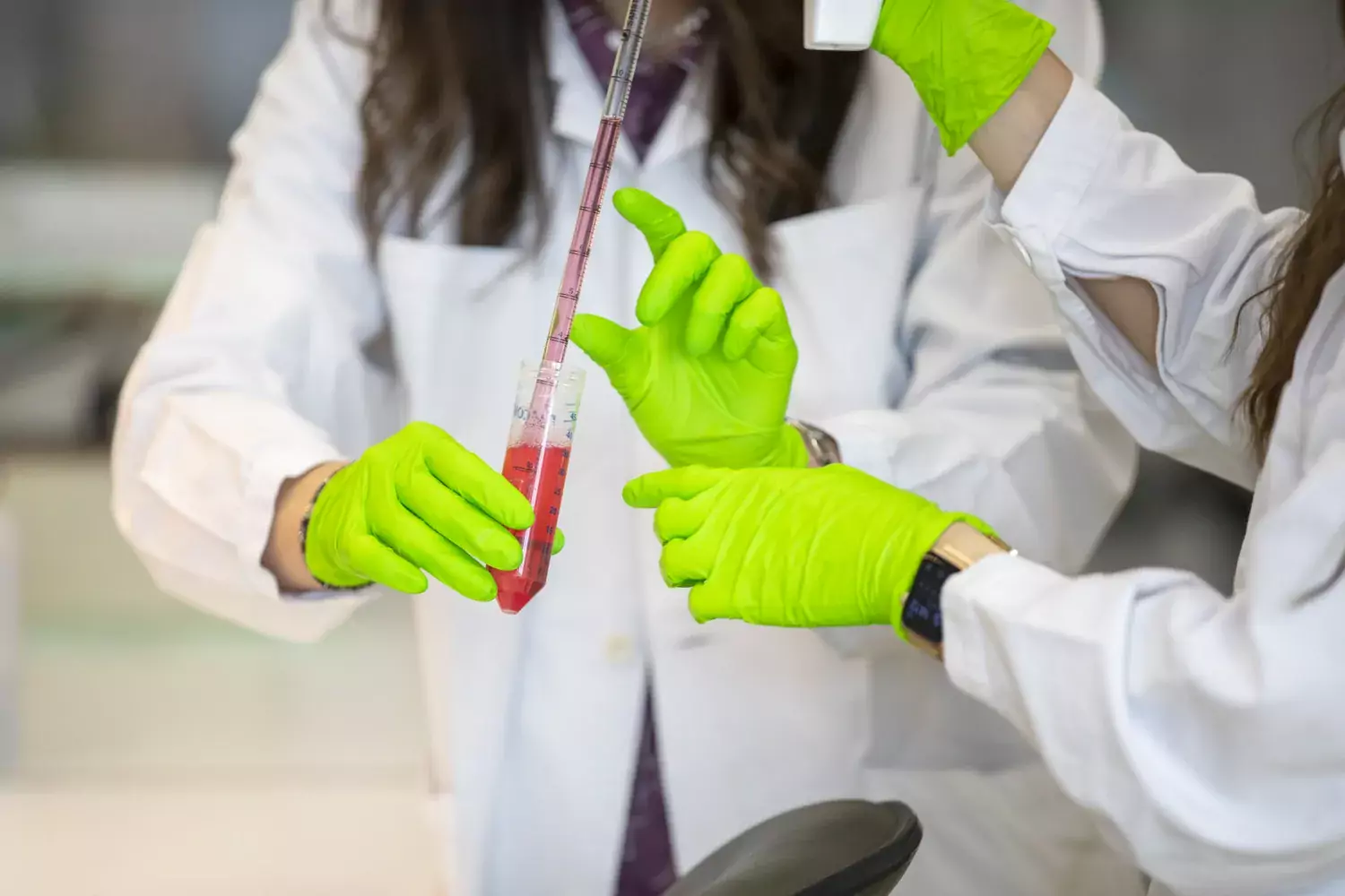 Händer jobbar med pipett och provrör.