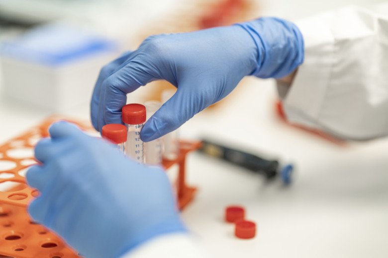 Händer i handskar som sorterar småflaskor.