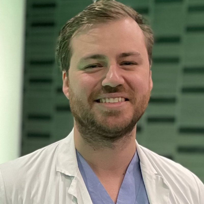 Porträtt av Marcus Skribek i blå och vita sjukhuskläder.