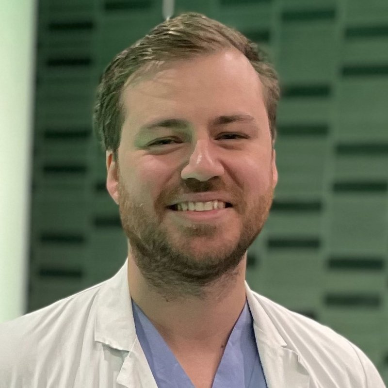 Portrait of Marcus Skribek in blue and white scrubs.