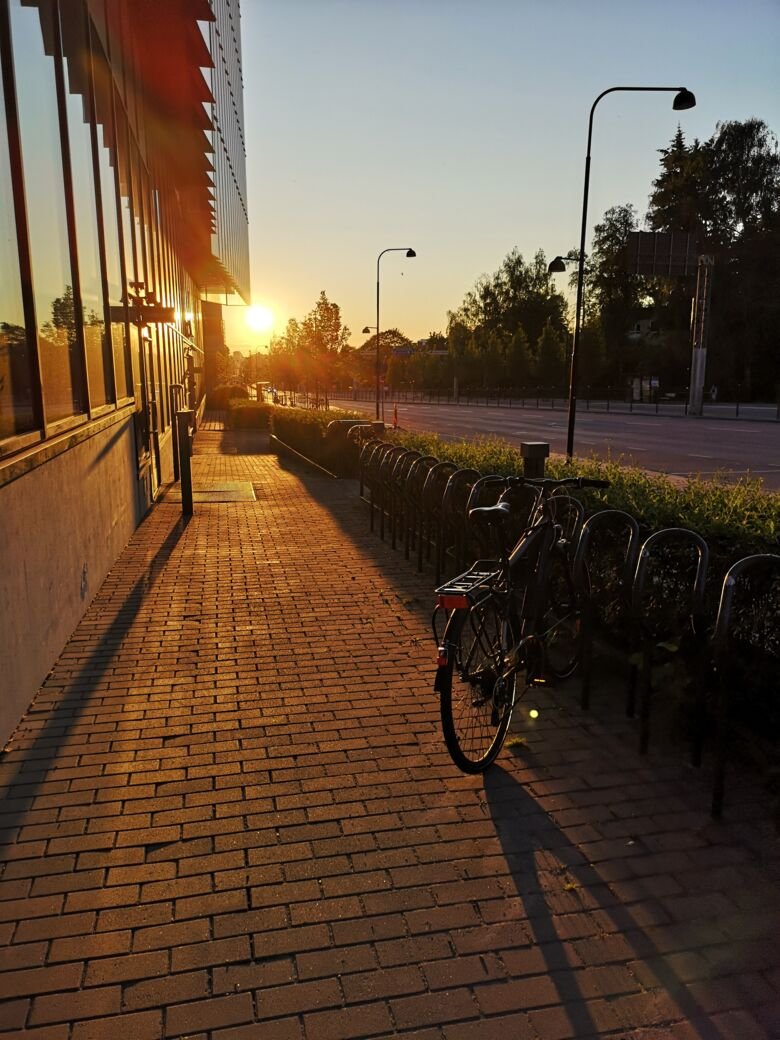 Decorative image of sunrise or sunset and the Biomedicum facade along Solnavägen.