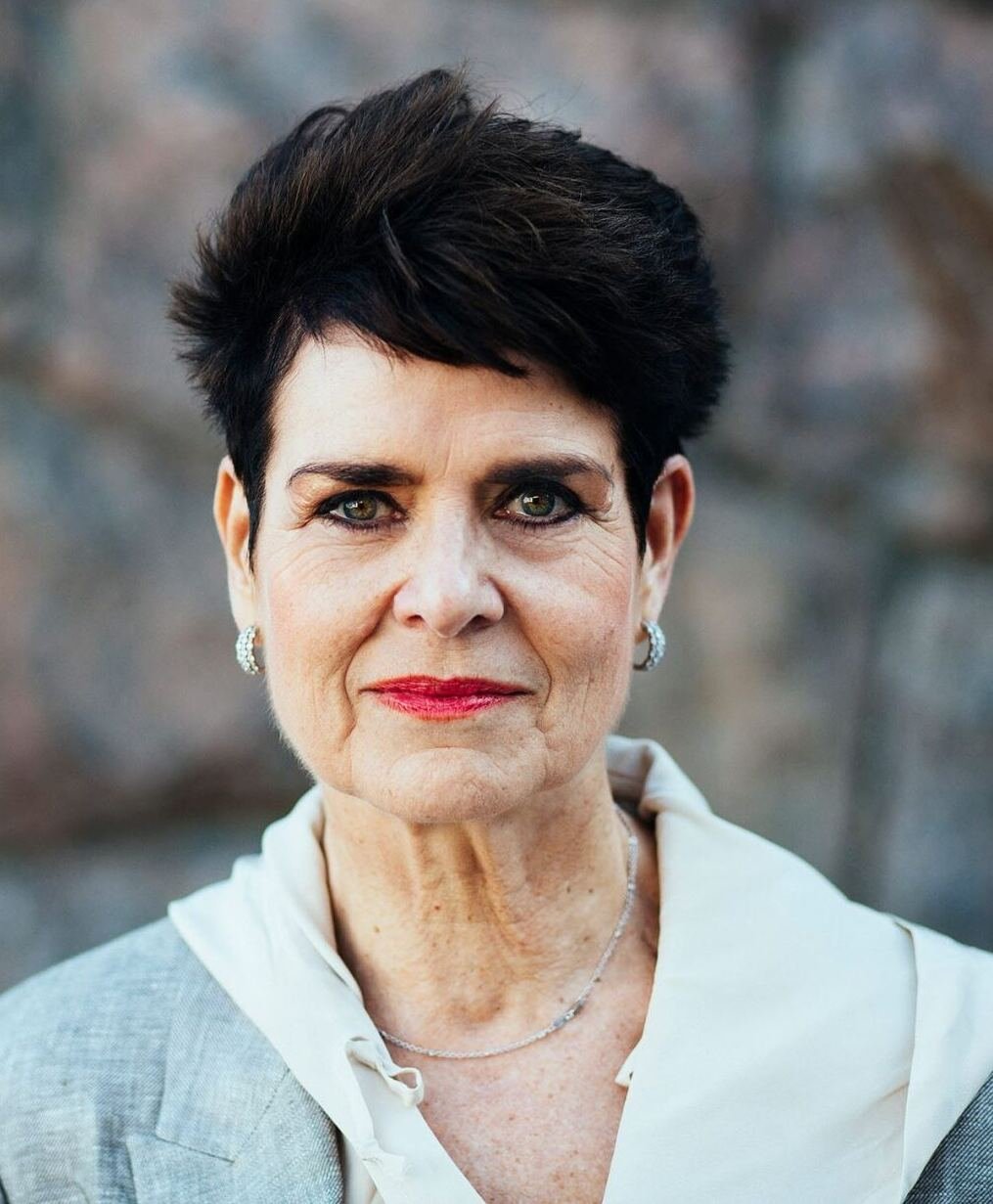 Porträtt av kvinna i ljus klädsel.