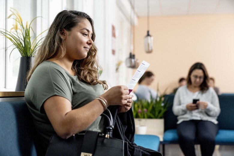 Sitter i väntrum och läser.