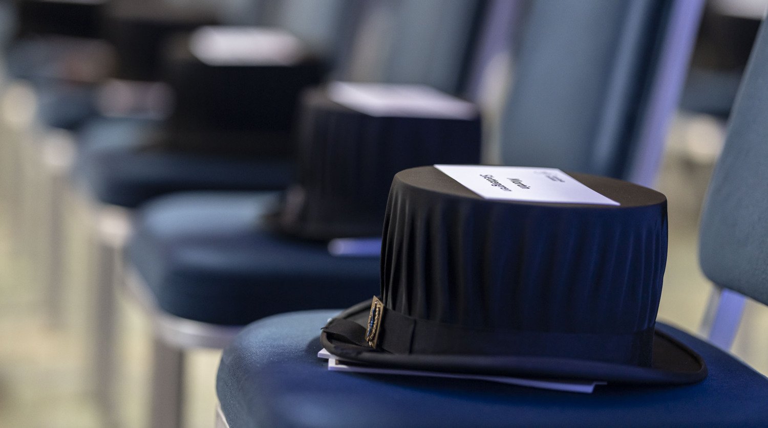 Doctor's hats and name tags on chairs standing in a row.