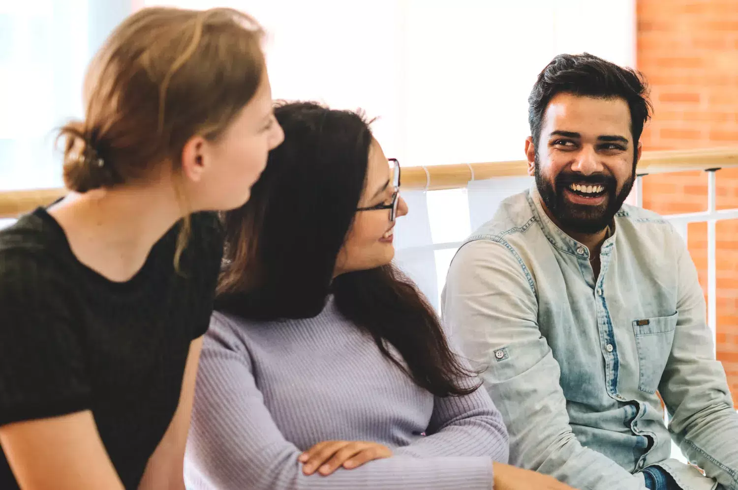 Two women and a man talking with each other.