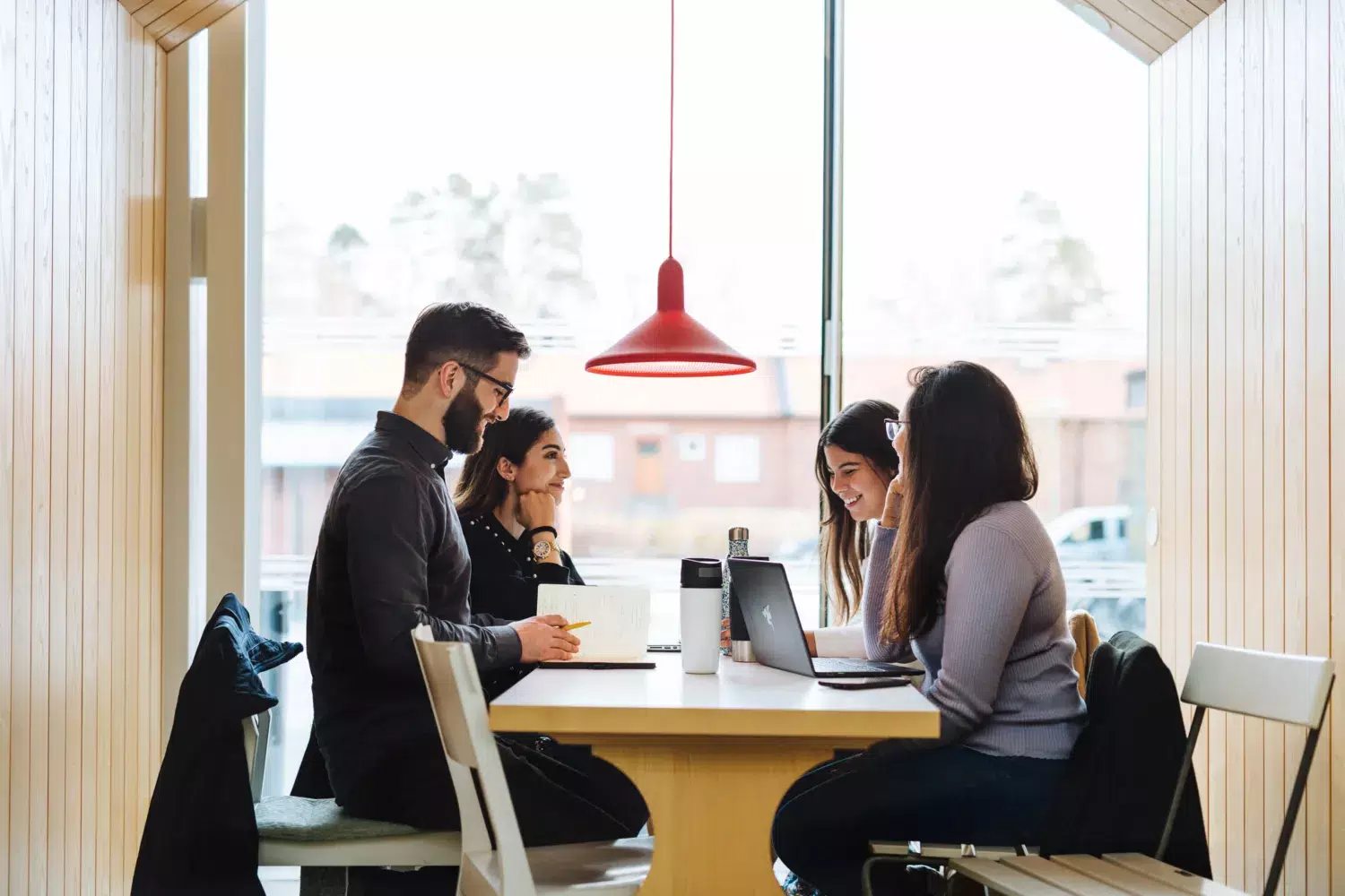 Four students sitting around a table and talking.