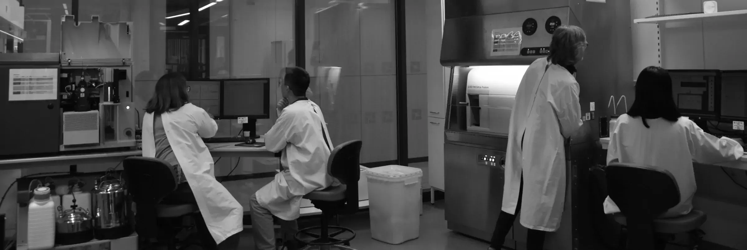 Members of the team in the core facility at different stations. Used as background image for the startpage.