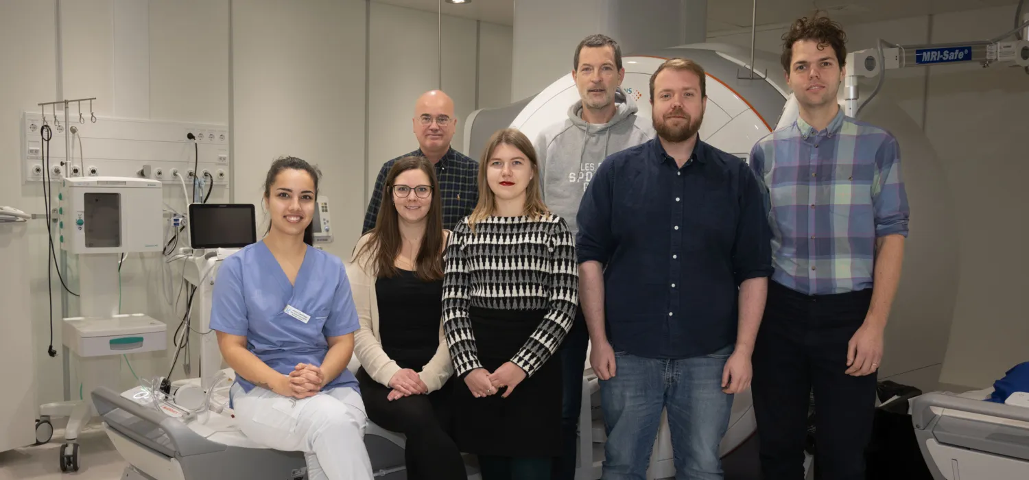 Sju forskare sitter vid en MR utrustning i sjukhusmiljö