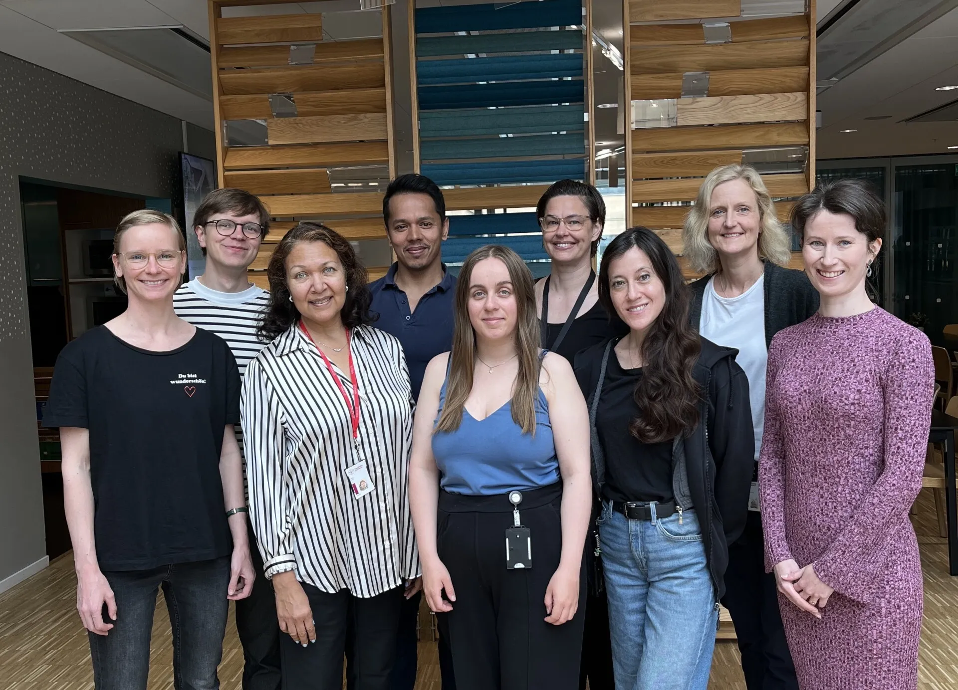 Group photo of nine people, taken indoors.