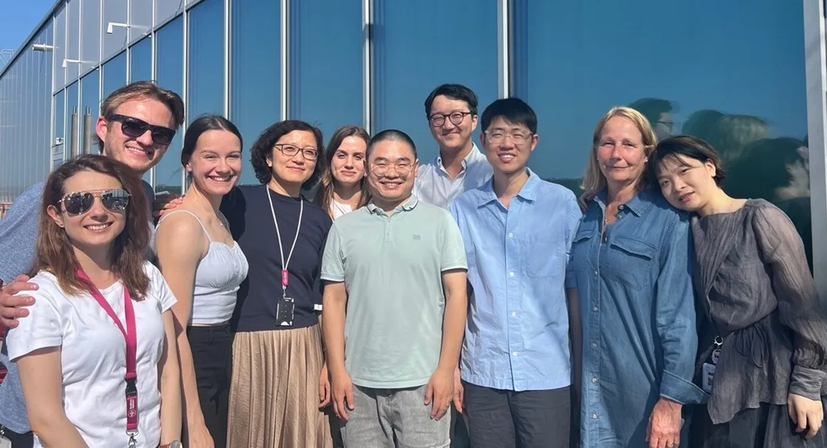 A group of people in front of a grey building