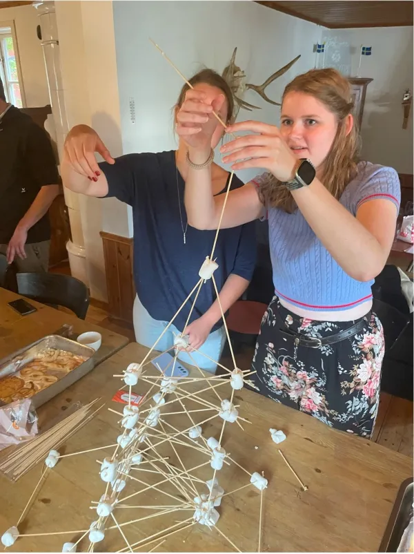 Two students building a structure with marshmallows.