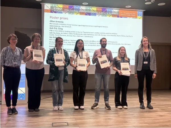 5 poster prize winners stood on stage holding their prizes.