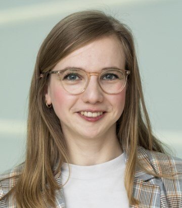 Porträtt av kvinna i ljus tröja och kavaj.